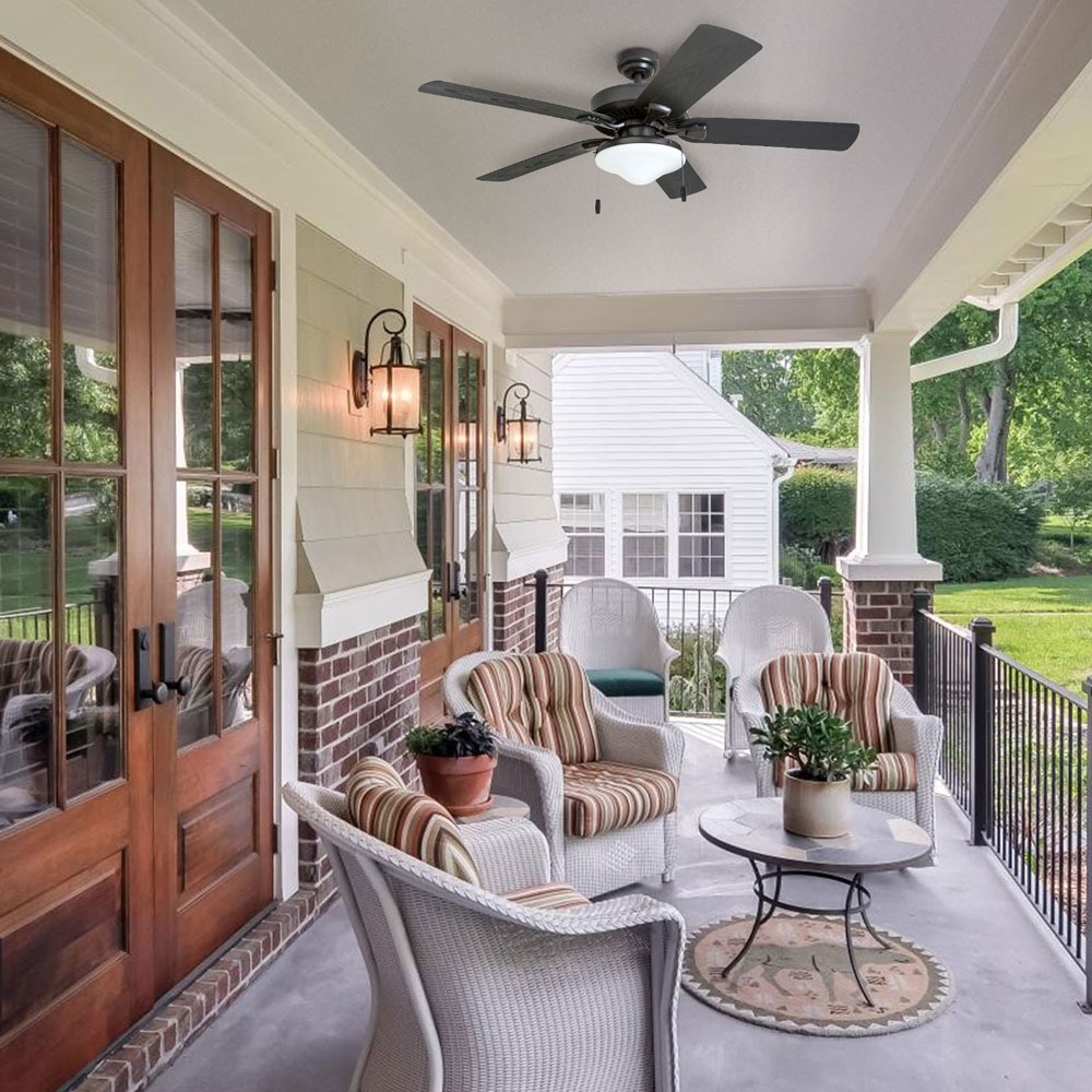 A porch with wicker furniture and a ceiling fan.